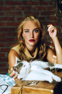 Portrait of confident young woman with cat