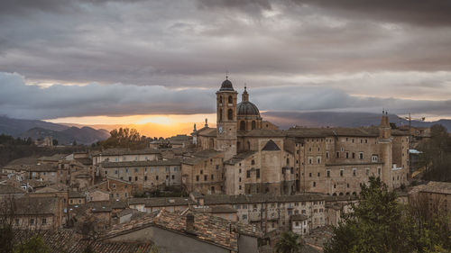 Buildings in city against sky during sunset