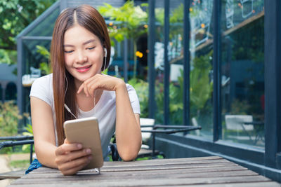 Young woman using mobile phone at camera