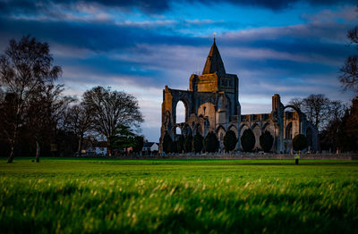 Crowland abbey, lincolnshire, uk from snowden field in low winter sunlight.