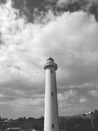 Low angle view of lighthouse by building against sky