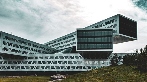 Low angle view of building by bridge against sky