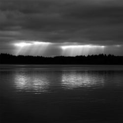 Scenic view of lake against cloudy sky