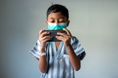 Portrait of boy holding mobile phone