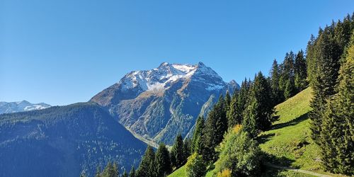 Scenic view of snowcapped mountains against clear blue sky