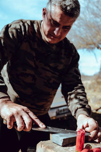 Man sharpening knife on rock