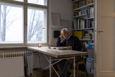 Senior man reading book at home