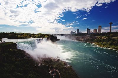 View of waterfall against cloudy sky