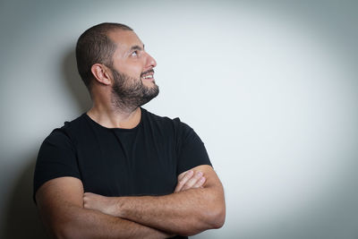 Young man looking away against white background