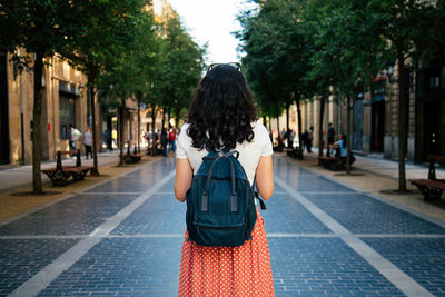 Rear view of woman standing on street in city