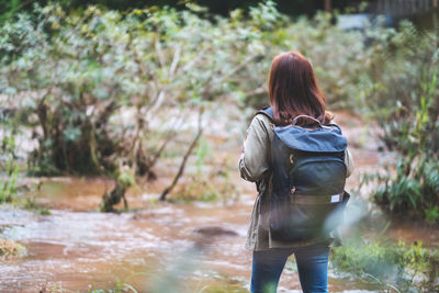 Rear view of woman standing in lake