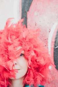 Close-up portrait of woman with red feathers on head