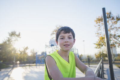 Portrait of smiling boy standing against sky