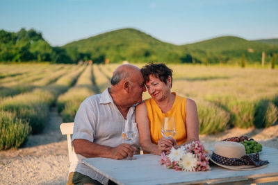 Portrait of smiling friends sitting on field