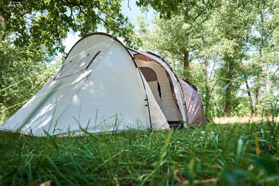 Tent on field against trees in forest