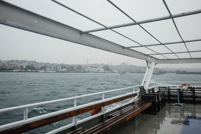 Bridge over river in city against sky