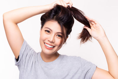 Portrait of a smiling young woman over white background