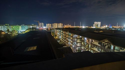 Illuminated buildings in city against sky at night