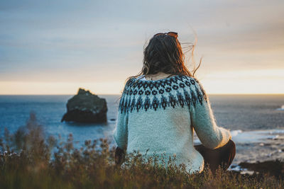 Rear view of woman looking at sea against sky