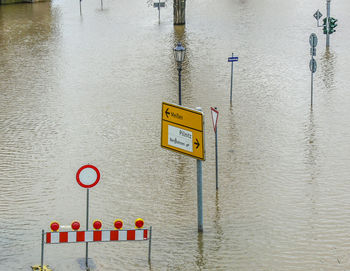 Close-up of warning sign by lake