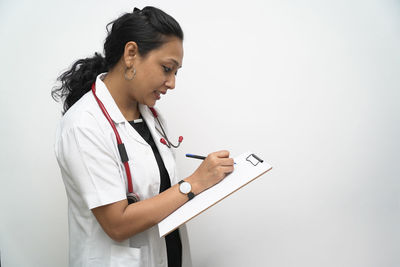Full length of woman standing against wall
