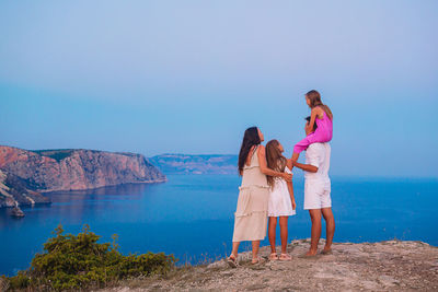 People standing on mountain against sky