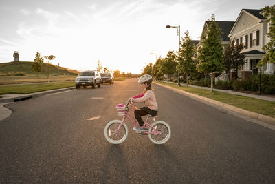 Woman riding bicycle on road against sky