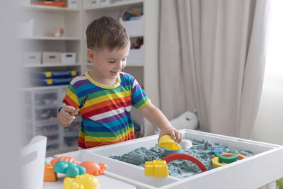 Portrait of boy playing with toys at home