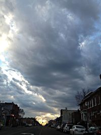 Cars on road against cloudy sky