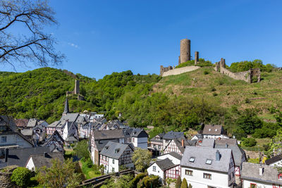 Buildings in town against clear blue sky