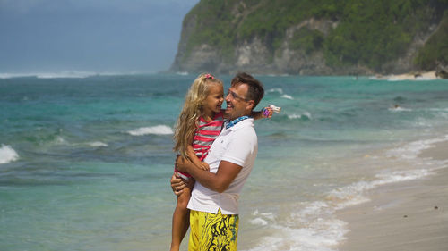 Father with daughter with child on the beach.