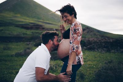 Side view of couple standing on field