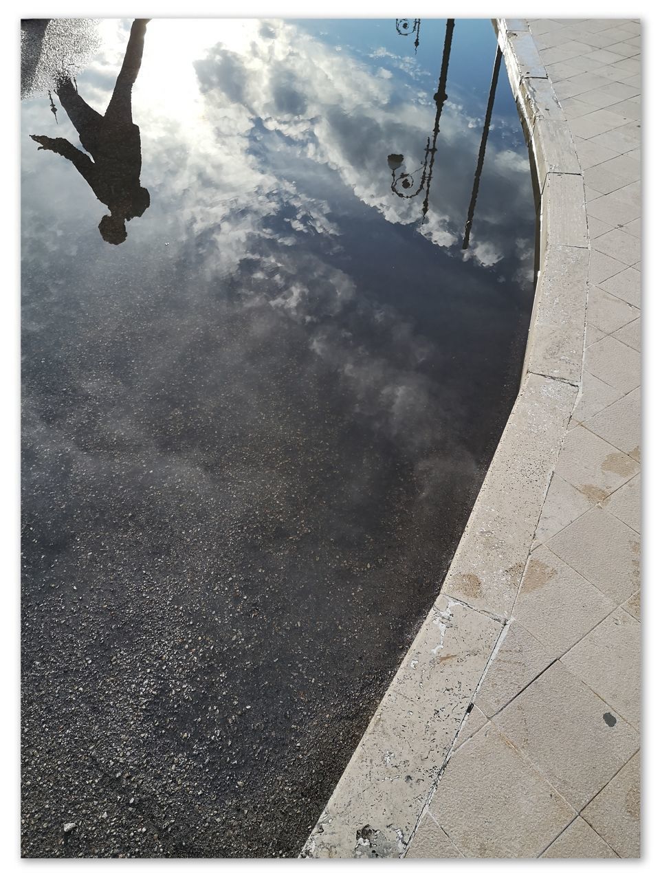 REFLECTION OF PERSON PARAGLIDING IN WATER