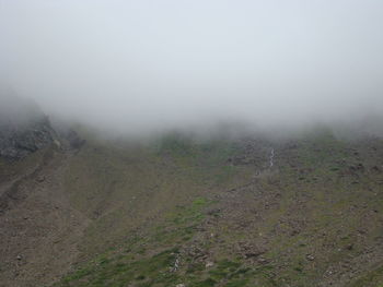 Scenic view of landscape against sky during foggy weather