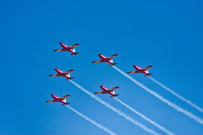 Low angle view of airshow against blue sky