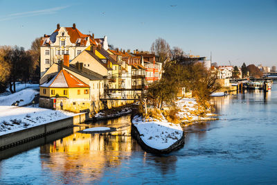 River in town against clear sky during winter