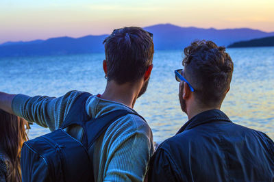 Friends against sea during dusk