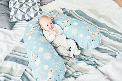 High angle view of baby lying on bed