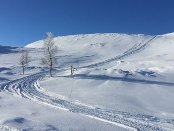 Scenic view of snowcapped mountains against blue sky