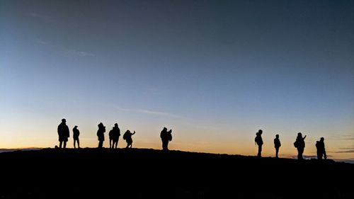 Silhouette people against clear sky during sunset