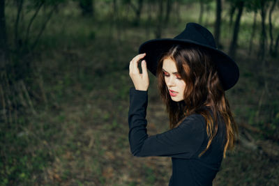 Young woman wearing hat standing on land