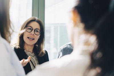 Businesswoman sharing ideas with colleagues during meeting