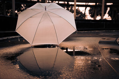 Umbrella by puddle on footpath