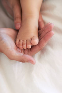 Low section of baby on bed