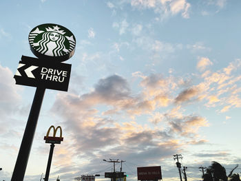 Low angle view of road sign against sky