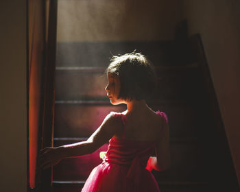 Woman looking through window at home