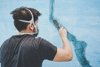 Rear view of man standing against wall