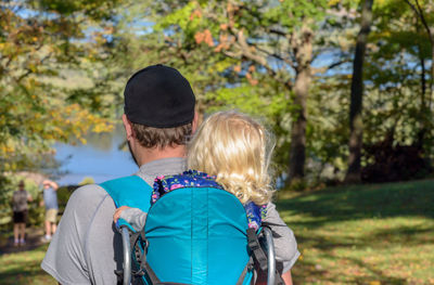 Rear view of man with daughter at park