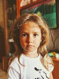 Close-up portrait of girl with blond hair at home