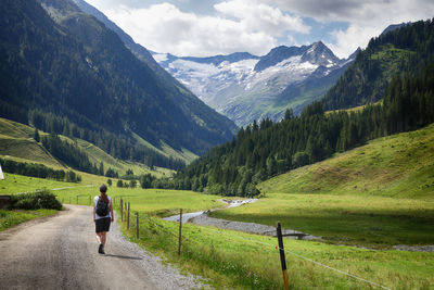 Rear view of man on field against mountains